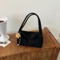 Vue détaillée du sac porté épaule en suédine noire avec charm fleuri, texture du tissu. - Avec Charme / Noir