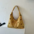 Sac bandoulière hobo en suédine jaune avec détails floraux noirs, grande capacité élégante. - Jaune