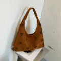 Borsa a tracolla hobo in camoscio marrone da donna, elegante borsa dumpling con intagli floreali. - Marrone