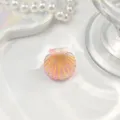 Nahaufnahme einer Mini-Haarklammer in Muschelform mit rosa Farbverlauf und Goldglitzer. - Rosa