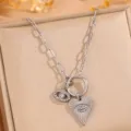 Close-up detail of silver titanium steel evil eye and sunburst heart pendant necklace. - Silver Eye Heart Necklace