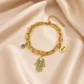 Gold titanium steel Hamsa hand evil eye charm bracelet detail showing intricate patterns. - 4 Evil Eyes Style