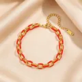 Gold and red enamel Cuban link bracelet close-up, showing delicate metal texture and vibrant color. - Red Enamel Bracelet