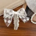 Detailed view of sweet Korean style white lace bow clear telephone cord hair tie with pearl decor. - White