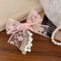 Detailed close-up view of the pink lace bow hair tie with crystal telephone cord and pearls. - Pink