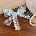Detailed close-up of the blue lace bow telephone wire hair tie featuring elegant pearls. - Blue