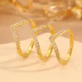 Close-up detail of three elegant geometric V-shaped gold rings featuring sparkling paved zirconia stones. - Size 6 / V Shaped Rhinestone Ring
