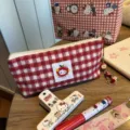 Red and white plaid cosmetic bag cute plush pencil case with apple pendant detail view. - Red Plaid Apple Pencil Case