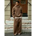Outdoor street style scene showing details of the brown fleece hoodie and wide-leg pants set. - Coffee Set