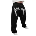 Vista detallada del estampado gótico en los pantalones de chándal anchos Y2K negros. - Negro