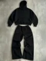 Detailaufnahme des schwarzen Hoodies und der weiten Jogginghose mit weicher Stofftextur. - S / Oberteil und Hose / Schwarz Set