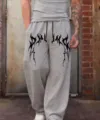 Vista detallada del pantalón de chándal gris holgado con estampado gótico oscuro Y2K. - Gris 1