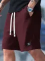 Detailed close-up of men casual waffle textured shorts with drawstring and patch. Perfect fit. - Burgundy