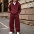 Street style detailed view of a solid color zip hoodie and wide leg sweatpants outfit. - Wine Red Set