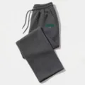 Detail of dark gray loose sweatpants featuring elastic drawstring waist and green Boston letter print. - Dark Gray