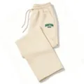 Beige wide leg sweatpants detail shot featuring an elastic drawstring waist and green graphic text. - Khaki