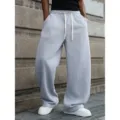 Detailed shot of men loose grey sweatpants with white drawstring, casual wide-leg street style. - S / Light Gray