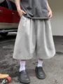 Detail view of men's casual solid color loose wide-leg knee-length shorts in gray. - S / Light Gray