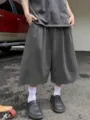 Detailed view of men's solid grey wide leg cropped shorts, casual loose streetwear style. - S / Dark Gray