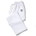 Vista detallada del pantalón blanco holgado con estampado de smiley gótico de ojos en cruz. - Blanco