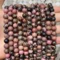 Close-up of pink and black mottled natural rhodonite round beads for jewelry making - Rhodonite with Black Veins AB