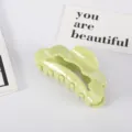 Vista detallada de pinza para el pelo grande de acetato verde claro con bordes ondulados - Verde matcha