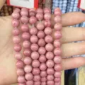 Detailed macro view of natural pink marbled stone beads for DIY jewelry and bracelets - Red Wood Grain A