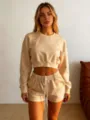 Detail view of women solid color crewneck long sleeve crop sweatshirt and shorts set. - S / Apricot
