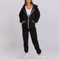 Detailed view of black fleece zip hoodie and sweatpants set, highlighting soft fabric and zipper. - Black