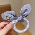 Purple satin bow hair scrunchie detail view with sparkling rhinestones and pearl decoration. - Purple Rabbit Ear Hair Tie