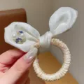 Close-up of cute white satin hair bow detail with pearls and sparkling heart crystals. - Yellow Rabbit Ear Hair Tie