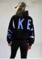 Detail view of black hoodie back with bold blue letter print and cozy hooded design. - Black with Blue Label