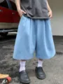 Close-up of casual light blue wide-leg culottes, loose summer shorts fit with streetwear vibe. - Light Blue