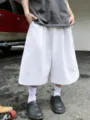 Detail shot of men's solid color loose wide-leg casual cropped shorts, street fashion style. - S / Bottoms / White