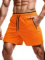 Detailed view of men's athletic running shorts with zipper pockets and quick-dry fabric. - S / Bottoms / Orange Red
