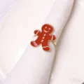 Close-up detail of the red enamel gingerbread man napkin ring with white icing and pearl accents. - Gingerbread Man Napkin Ring