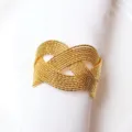 Goldener geflochtener Serviettenring Detailansicht, elegante Tischdeko für edles Abendessen. - Weizen