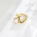 Close-up of asymmetrical twin crystal ring with emerald and pear cut stones in gold finish. - Size 6 / Gold Style / White