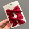 Elegantes lazos de pelo de satén rojo para niñas en una tarjeta blanca de producto - Un par / Burdeos