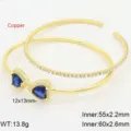 Dettaglio del doppio bracciale dorato in rame con zirconi blu a forma di cuore. - Blu