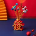 Festliches Tischornament mit roter Fa-Zeichen-Basis und bunten Strass-Stielen dekoriert. - Gypsophila Wohlstand