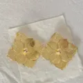 Vista dettagliata di orecchini floreali in acciaio inossidabile placcato oro 18k per banchetti. - Stile Petalo Quadrato Oro 18K (1)
