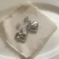 Vista di dettaglio di orecchini a cuore argentati con zirconi, stile elegante e di lusso. - Stile Cuore Classico (1) / Argento