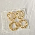 Close-up detail of gold geometric hammered double circle earrings showcasing unique texture. - Fluid Streamlined Irregular Style (2)