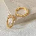 Orecchini incrociati in zirconia cubica dorata dettaglio, elegante gioiello di design geometrico. - Stile Linee Incrociate Dorato