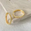 Primo piano dettagliato di orecchini a cerchio dorati con zirconi scintillanti. - Stile Ondulato Linee Dorato