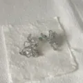 Primo piano di orecchini a lobo floreali 3D irregolari in metallo con cristalli. - Stile Floreale 3D (2) / Argento