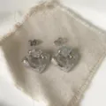 Primo piano di orecchini a lobo a cuore argentati con dettagli in zircone cubico scintillante. - Stile Cuore Micro-intarsiato (2) / Argento