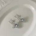 Prachtige zilverkleurige zirkonia vlinder oorbellen met elegante grijze parels voor dames. - Zilver met grijze parel