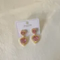 Close-up detail of double heart pink crystal stud earrings with gold plating court style. - Heart Pink